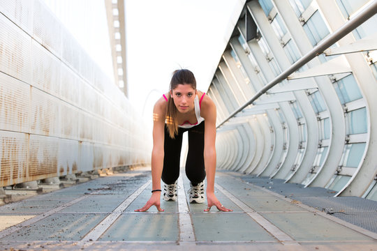 Beautiful Young Woman Getting Ready To Run On A Modern Bridge