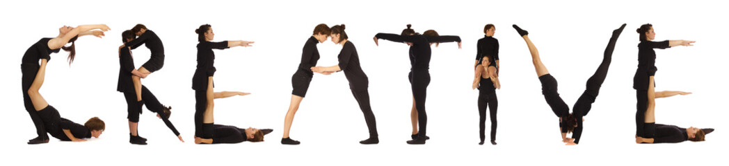 Fototapeta premium Group of black dressed people standing forming CREATIVE word