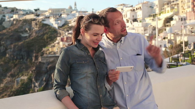 Tourist couple with smartphone on Santorini