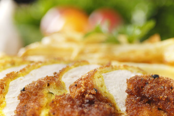 French fries and chicken on the plate on the wooden table