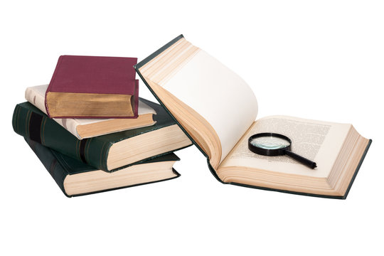 stack of books with a magnifying glass