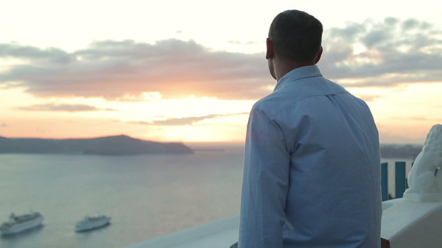Man looking at beautiful sunset over island