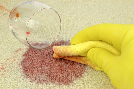 Cleaning up a spilled glass of red wine on a carpet