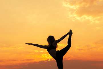 girl does yoga at sunset