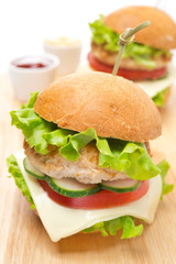 chicken burger with vegetables, cheese, ketchup and mustard