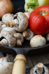 Mushrooms and fresh vegetables on the rusty pan