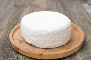 Fresh cottage cheese on a wooden plate