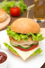 homemade chicken burger with ketchup and mustard on a plate