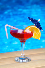 Tasty cocktail on swimming pool background