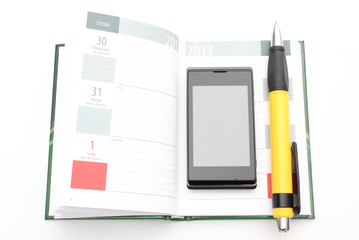 Modern mobile phone and yellow pen lying on open calendar