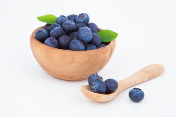 fresh blueberry in a wooden bowl, over a white background.