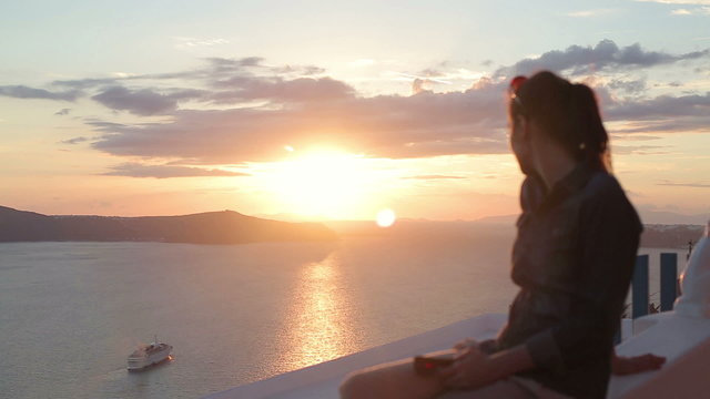 Woman looking at beautiful sunset over island