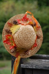 Hut aus Stroh mit Herbstlaub und lustigen Bändern