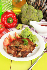 Piece of fried meat on plate on wooden table close-up