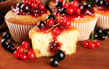 Tasty muffins with berries on wooden table