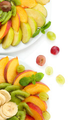 Assortment of sliced fruits on plates, isolated on white