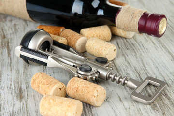 Corkscrew with wine corks and bottle of wine