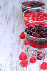 Jelly with fresh berries on wooden table close up