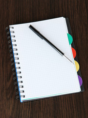 Notebook and pen on wooden table