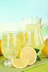 Delicious lemonade on table on light blue background