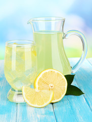 Delicious lemonade on table on blue background