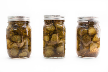 Three jars of pickes in mason jars on a white isolated background