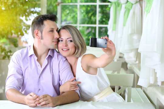 Young Couple  Taking  Photo With  Mobile Phone In Restaurant