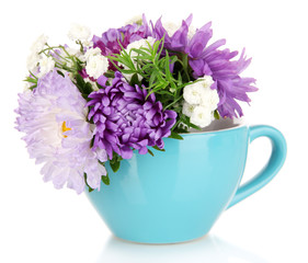 Beautiful bouquet of bright flowers in color mug, isolated