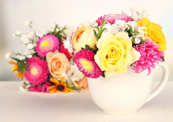 Beautiful bouquet of bright flowers in color mug,