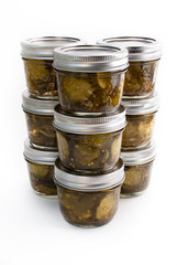 Nine jars of pickes stacked on a white isolated background