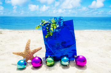 Starfish with Christmas balls and gift bag on the beach