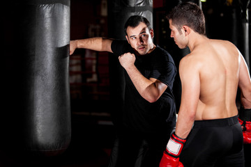 Fototapeta na wymiar Boxer and coach training at a gym