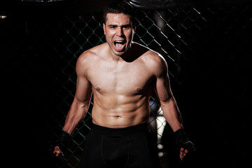 Fototapeta na wymiar Angry MMA Fighter in a cage