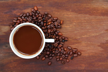 Cup coffee and beans on wood background
