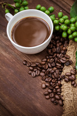 Cup coffee and beans on wood background