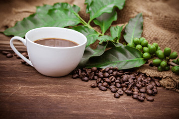 Cup coffee and beans on wood background