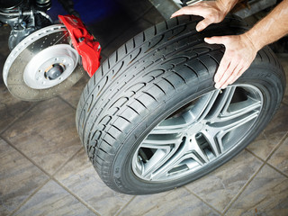 Car mechanic is changing a tyre in a garage