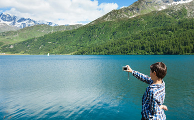 boy on the shore of a mountain lake