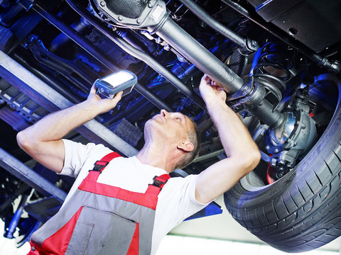 Car mechanic inspecting the engine of a car