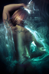 Nude blond woman with tribal tattoo and fiber effects