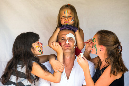 Children paints face of his father (Happy family concept)