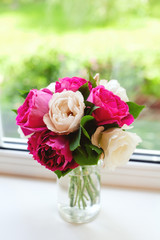 white and violet roses on window sill