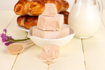 Dry yeast with pastry on wooden table close-up