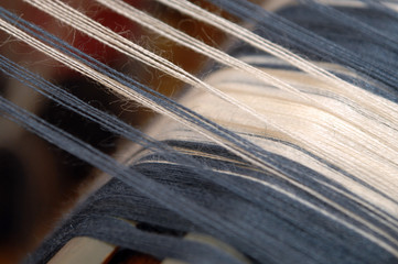 Closeup, blaue und weiße Fäden am Webstuhl