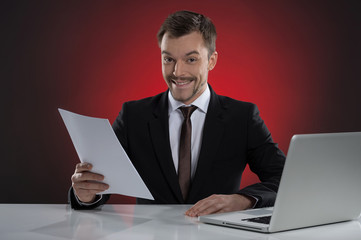 Happy businessman. Cheerful young businessman holding a paper an