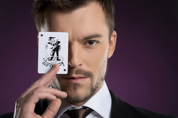 Joker man. Portrait of confident young businessman holding a jok