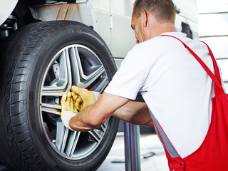 Car mechanic is changing a tyre