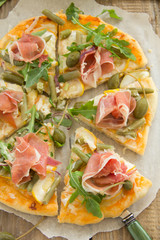 Pizza with arugula and prosciutto.
