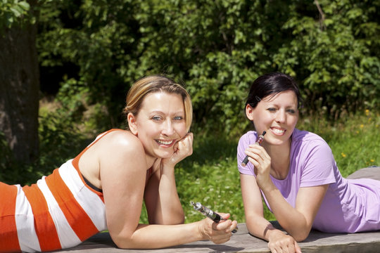 Zwei Frauen in der Natur mit E-Zigaretten