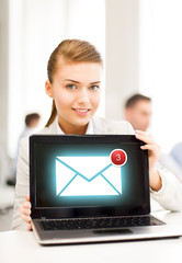 businesswoman holding laptop with email sign